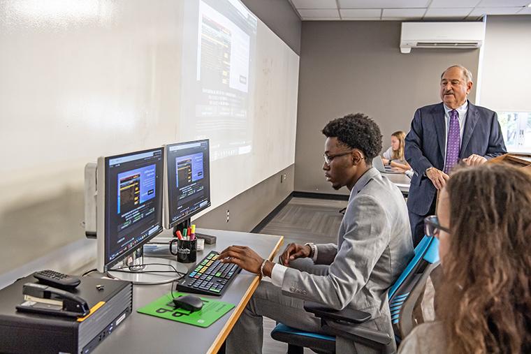 A student 使用 the new Bloomberg Terminal during class as Professor Richard Bookbinder 看起来在.